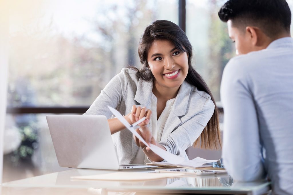 Businesswoman discusses document with colleague